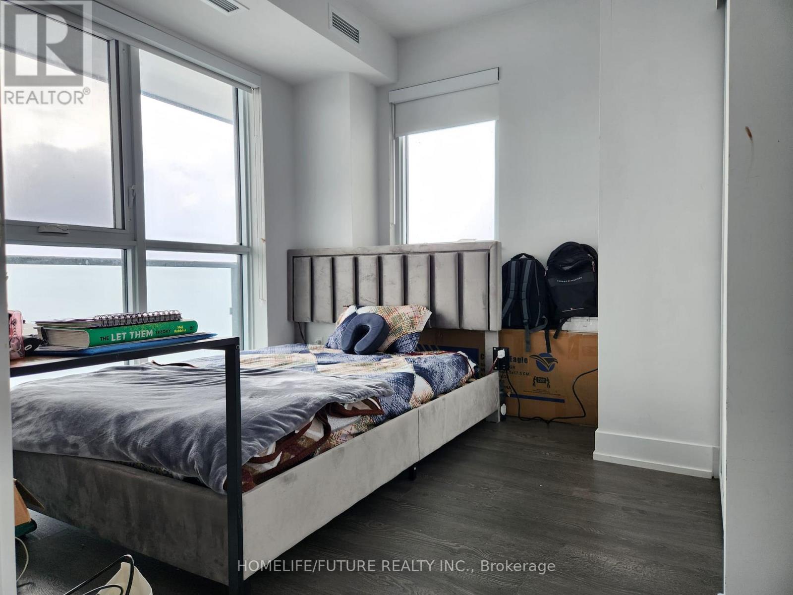 A bedroom with a large bed and a window overlooking the water.