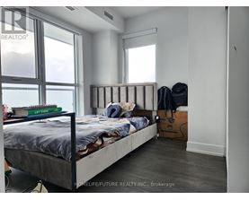 A bedroom with a large bed and a window overlooking the water.