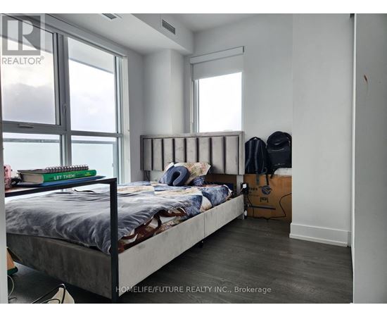 A bedroom with a large bed and a window overlooking the water.