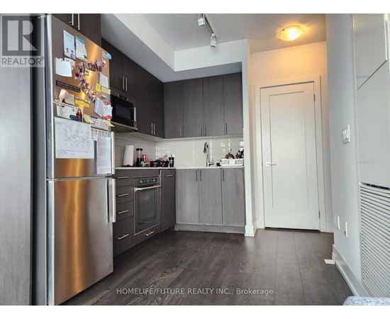 A kitchen with a refrigerator covered in papers.