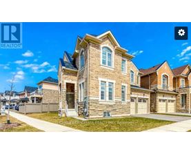 A large, well-maintained house with a stone facade and multiple garages is for sale.