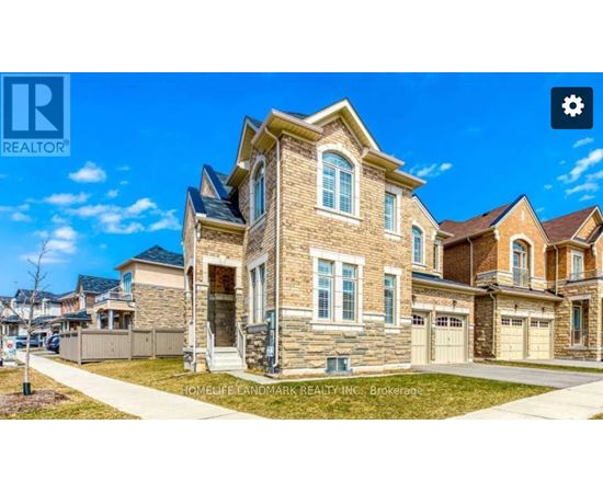 A large, well-maintained house with a stone facade and multiple garages is for sale.