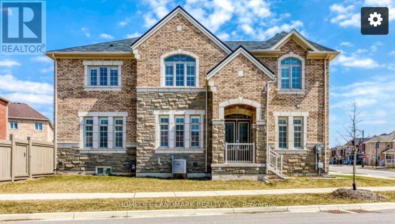 A large brick house with a gated driveway in front.