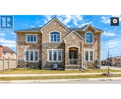 A large brick house with a gated driveway in front.