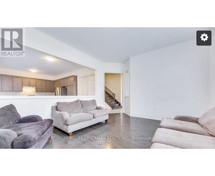 A living room with a grey couch and a wooden cabinet.
