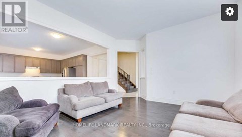 A living room with a grey couch and a wooden cabinet.