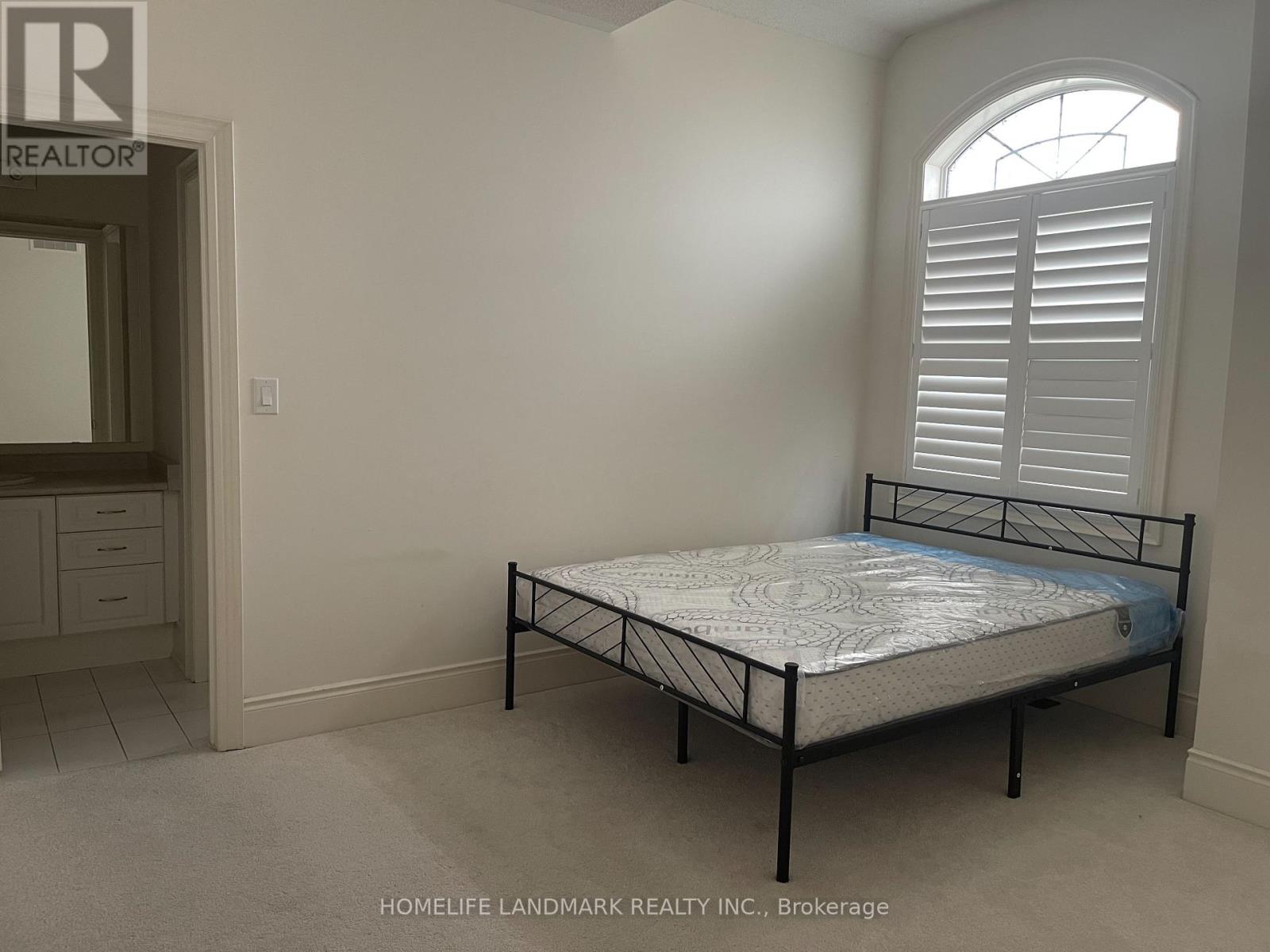 A bedroom with a bed, dresser, and window.