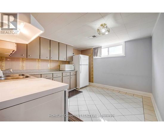 A kitchen with white cabinets and a white refrigerator.
