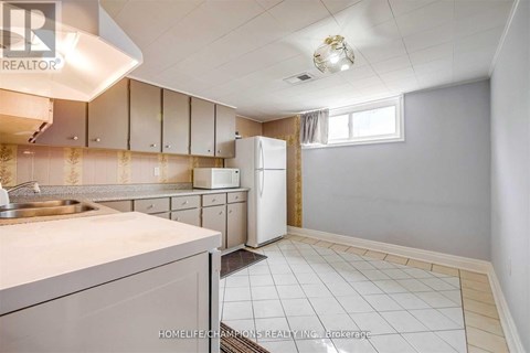 A kitchen with white cabinets and a white refrigerator.