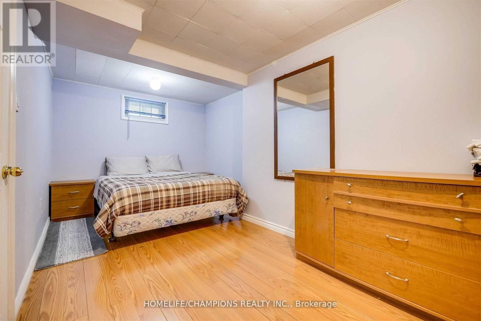 A bedroom with a bed, dresser, and mirror.