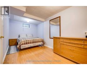 A bedroom with a bed, dresser, and mirror.