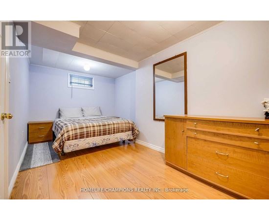 A bedroom with a bed, dresser, and mirror.
