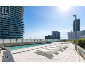 A sunny day at a rooftop pool with loungers and a view of the city.
