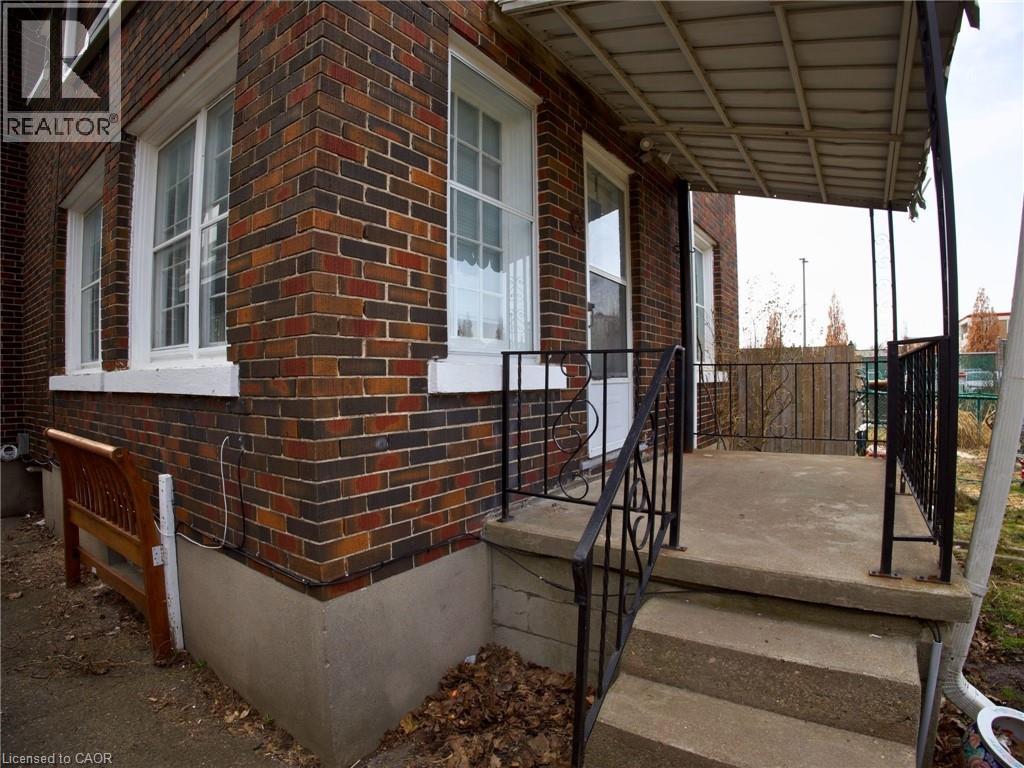 A brick house with a porch and a black railing.