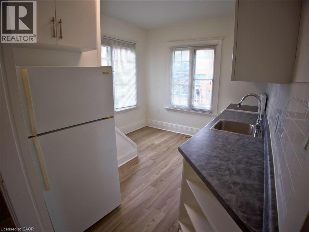 A kitchen with a white fridge and a black counter top.