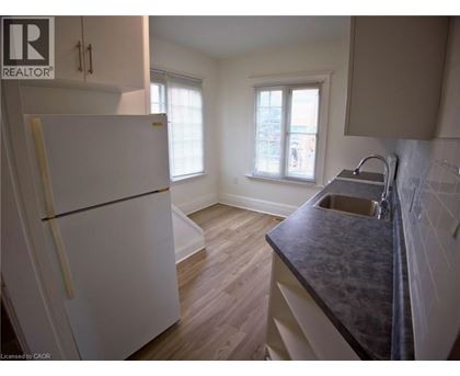 A kitchen with a white fridge and a black counter top.