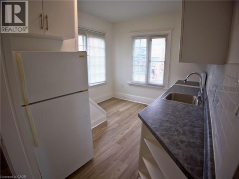 A kitchen with a white fridge and a black counter top.
