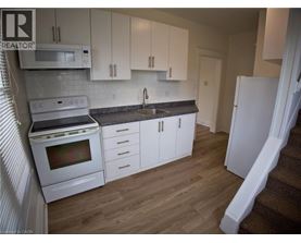 A kitchen with white cabinets and a white fridge.