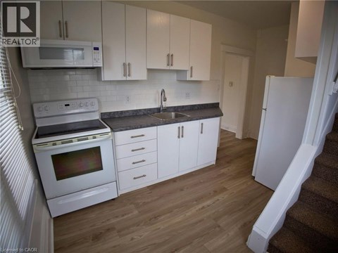 A kitchen with white cabinets and a white fridge.