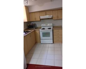 A white stove in a kitchen with wooden cabinets.