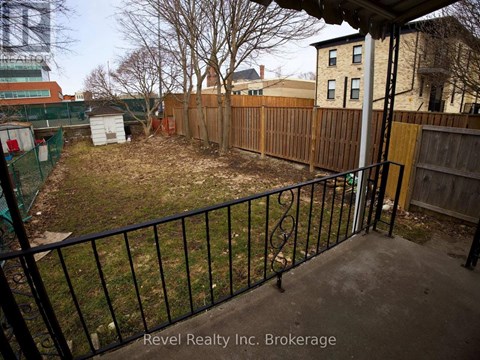 A backyard with a black fence and a green building in the background.