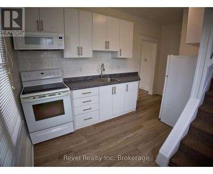 A kitchen with white cabinets and appliances is for sale.