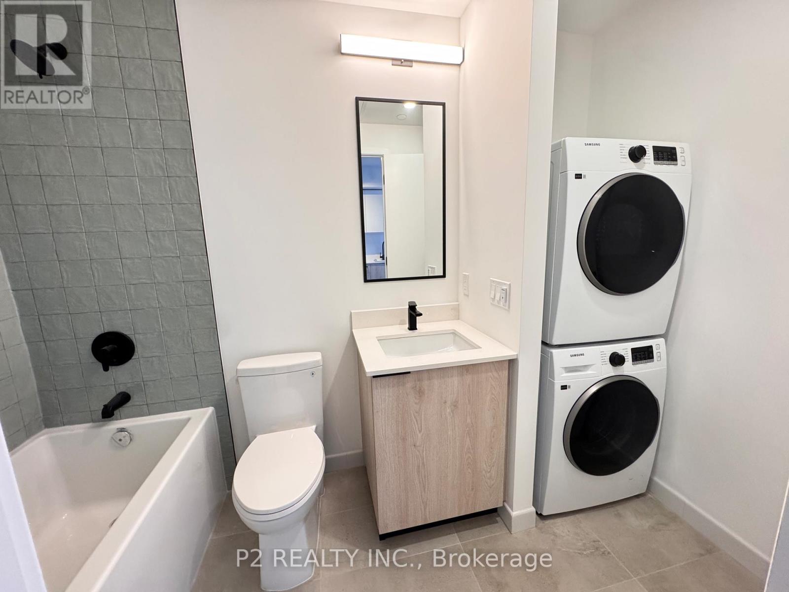 A bathroom with a toilet, sink, and washer and dryer.