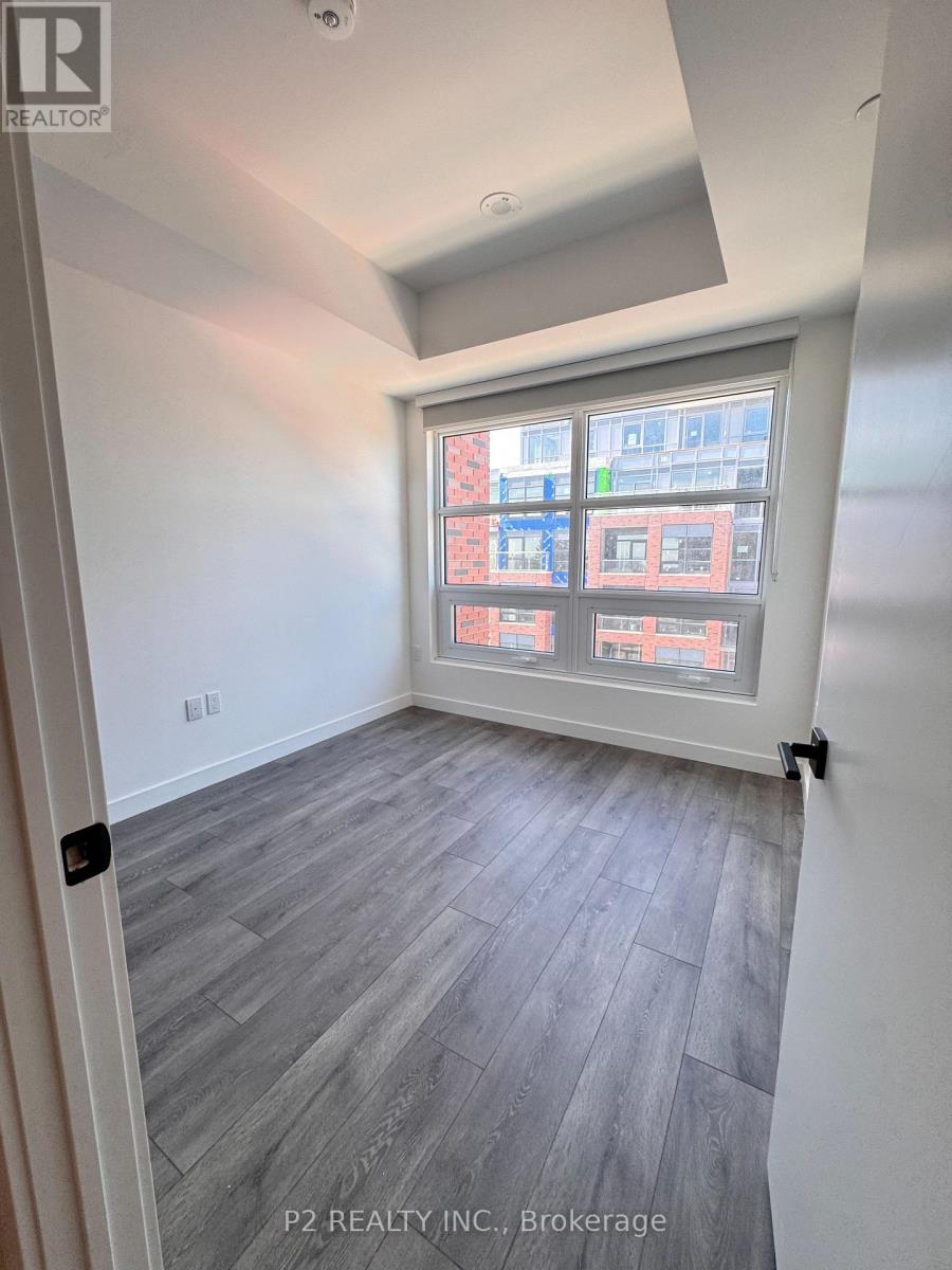 A room with a window showing a view of a red building.