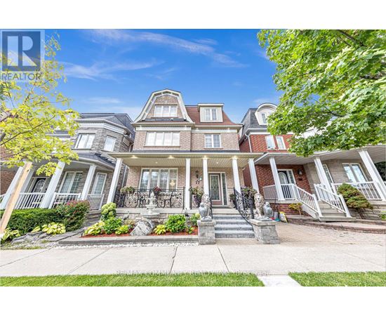 A large, well-maintained house with a front porch and multiple windows.