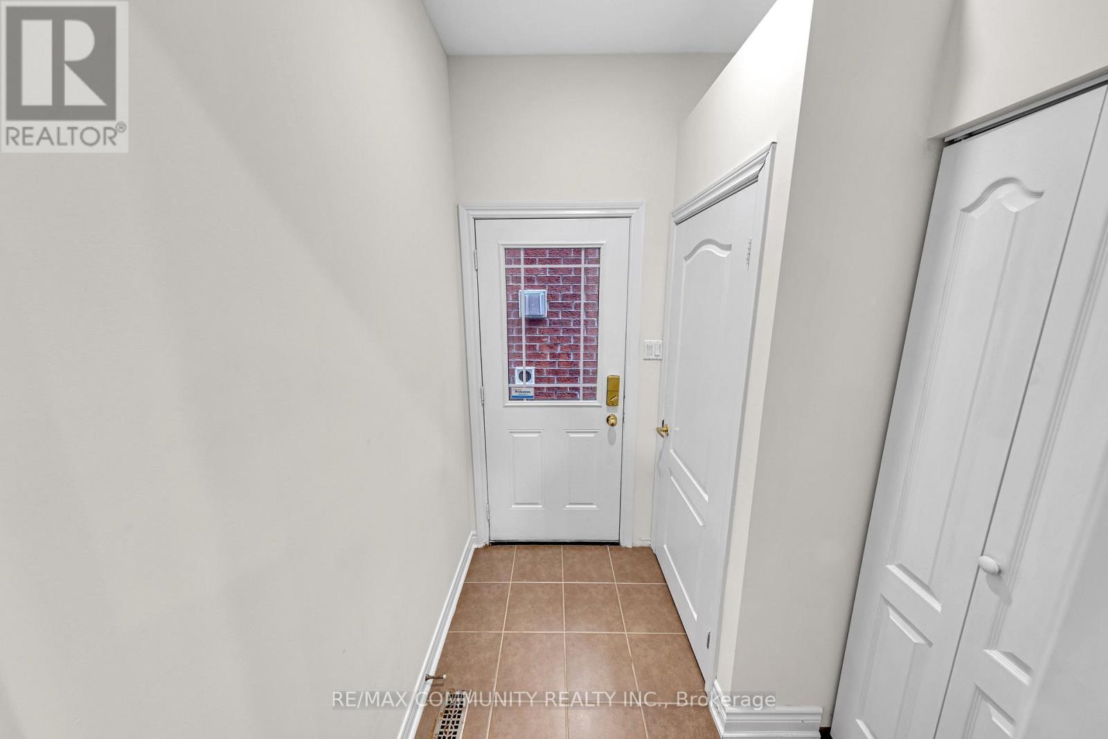 A hallway with white doors and a tiled floor.