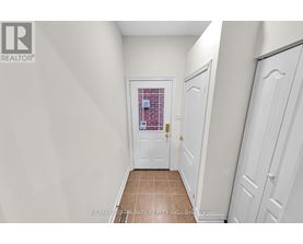 A hallway with white doors and a tiled floor.