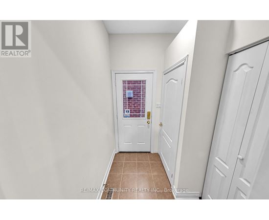 A hallway with white doors and a tiled floor.