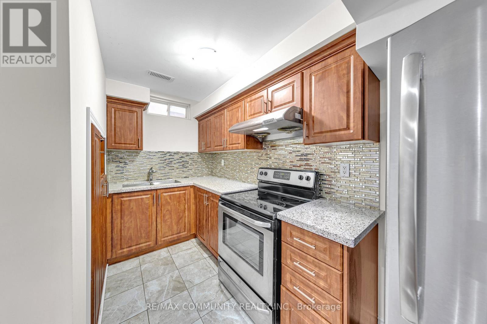 A kitchen with wooden cabinets and a granite countertop.