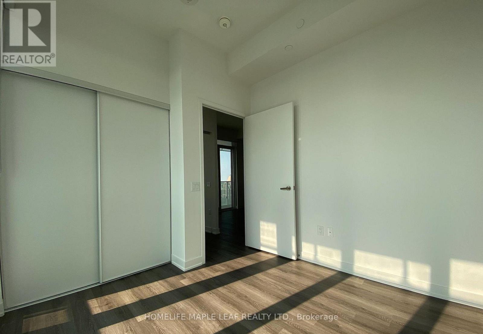 A room with a door and a window with sunlight coming through.