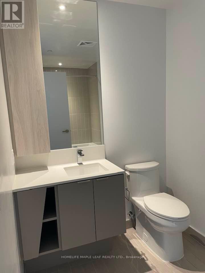 A white toilet sits next to a sink in a modern bathroom.