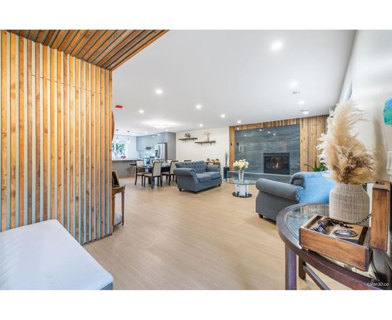 A modern living room with a fireplace and a dining area.
