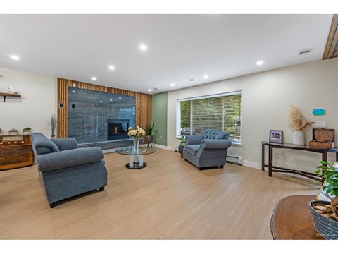 A living room with a grey couch and a glass coffee table.