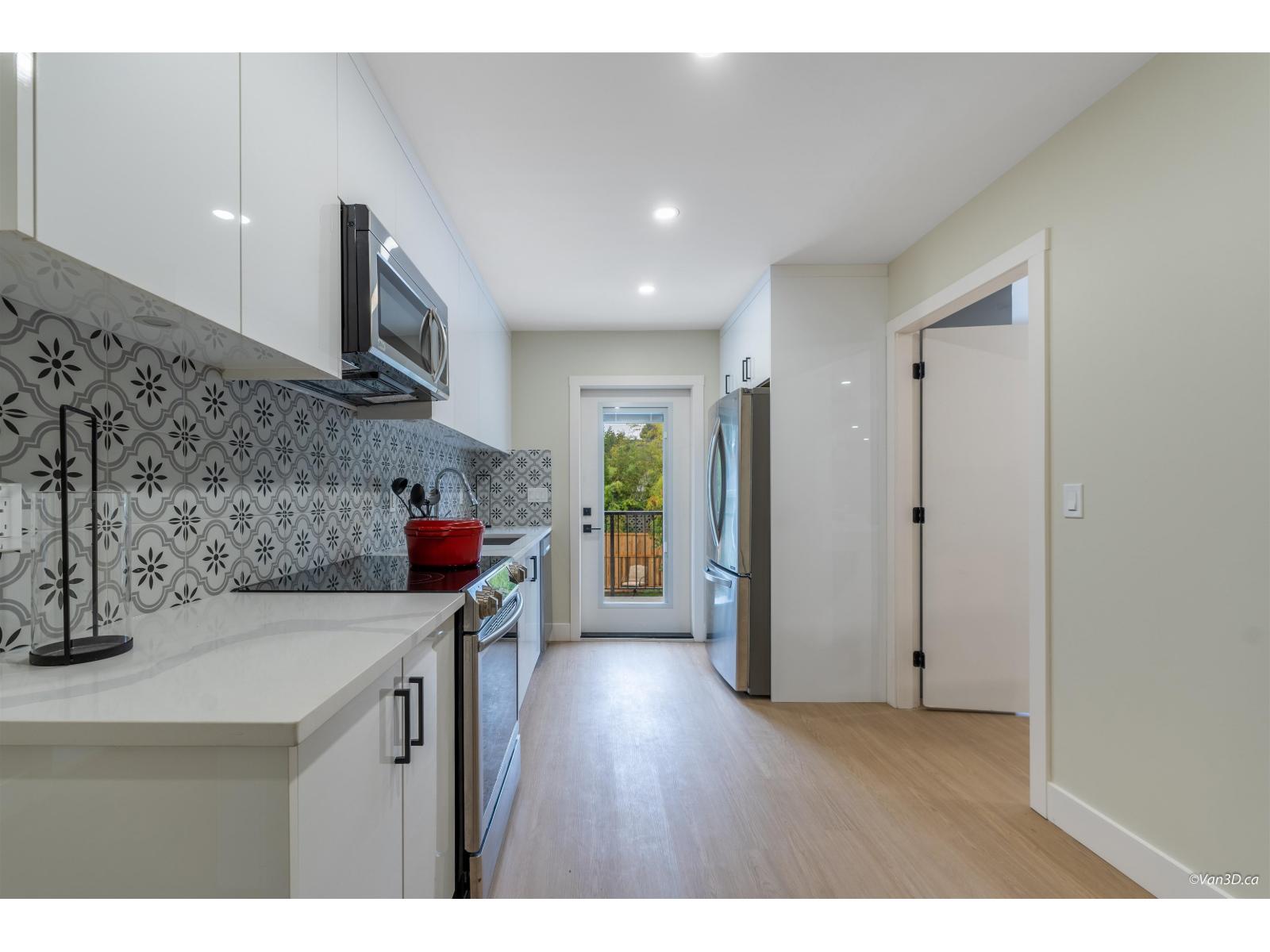 A kitchen with a white counter top and a black microwave above it.