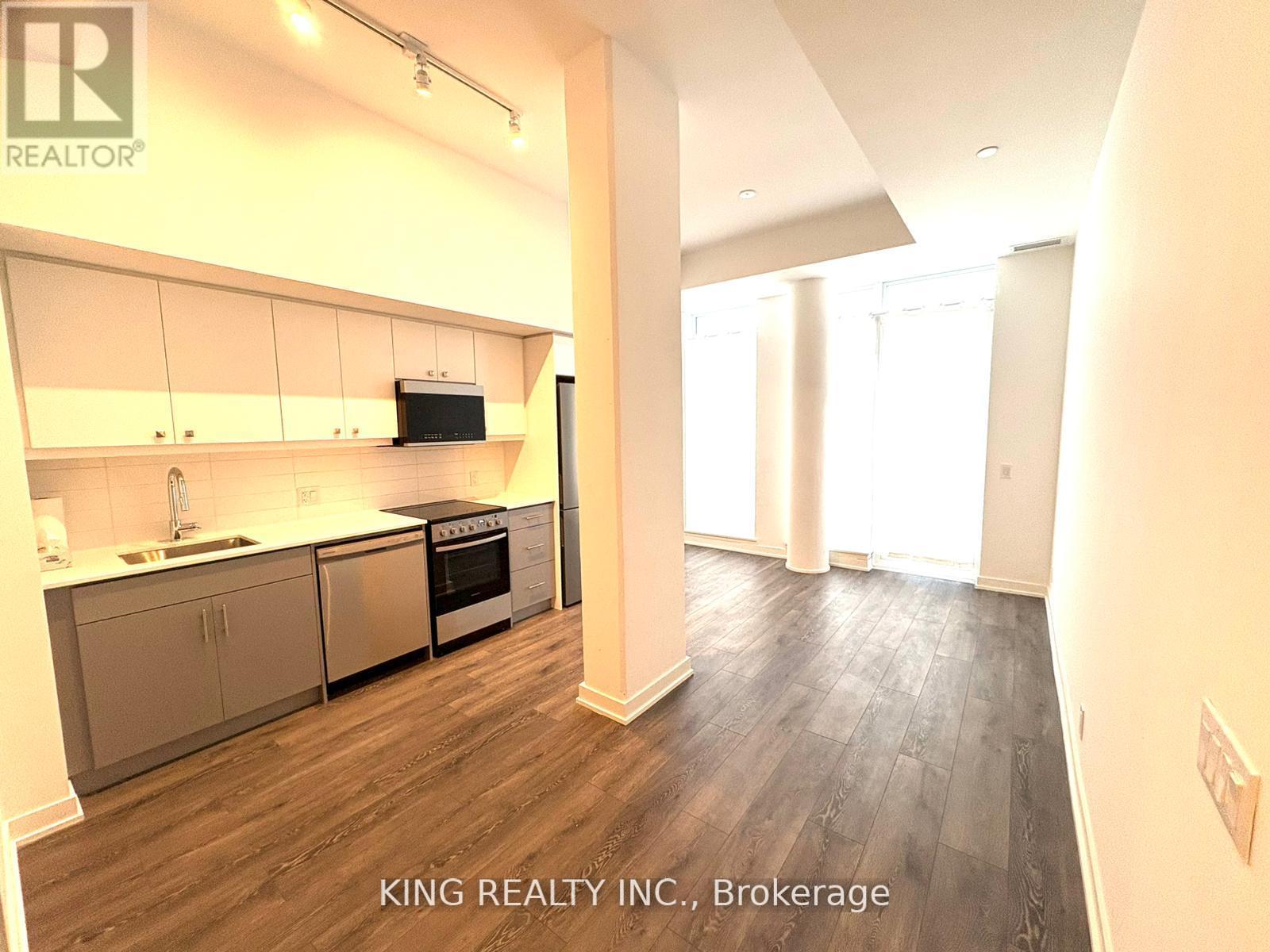 A kitchen with a stove top oven and a microwave built into the cabinetry.