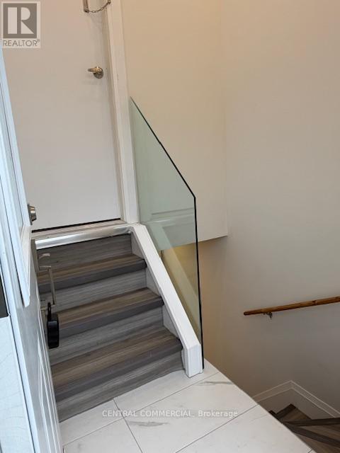 A staircase with a glass railing and wooden steps.