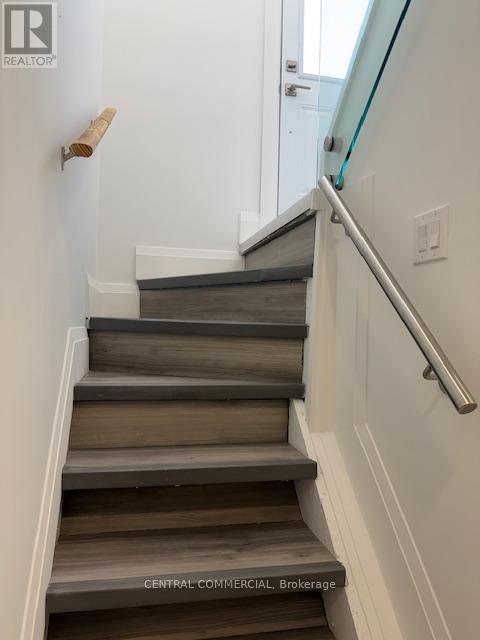 A staircase with a glass railing and wooden steps.