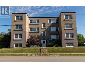 A large apartment building with a sign that says EXP REALTY Brokerage.