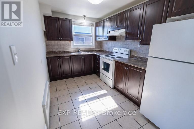 A kitchen with brown cabinets and a white refrigerator.