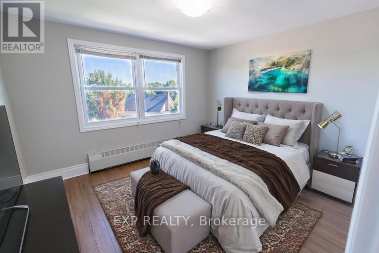 A bedroom with a large bed and a painting on the wall.