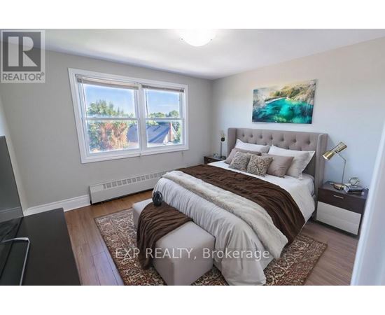 A bedroom with a large bed and a painting on the wall.