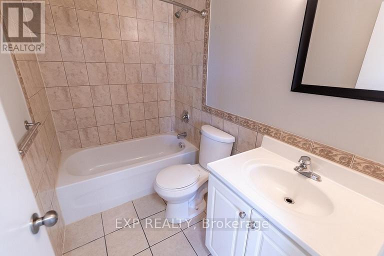 A bathroom with a white toilet, a white sink, and a white bathtub.