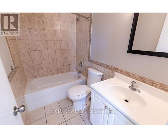 A bathroom with a white toilet, a white sink, and a white bathtub.