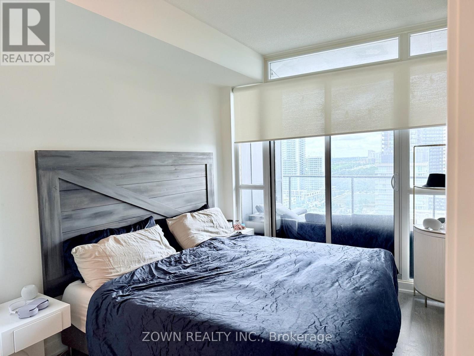 A bedroom with a large bed and a view of the city.