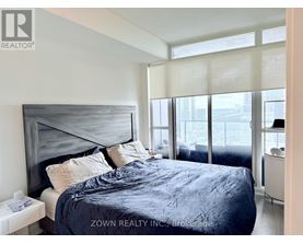 A bedroom with a large bed and a view of the city.