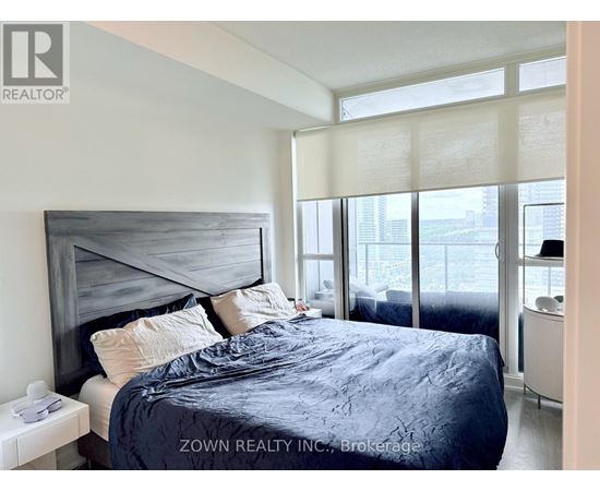 A bedroom with a large bed and a view of the city.